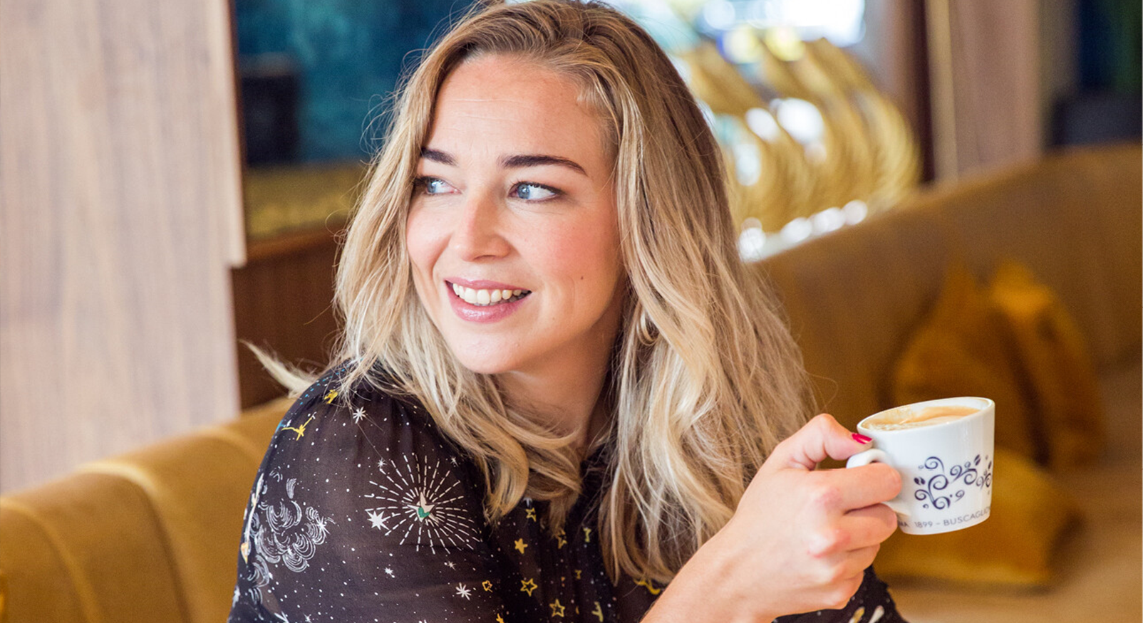 Woman with coffee laughs, representing choice not to want children and focus on own lifestyle.