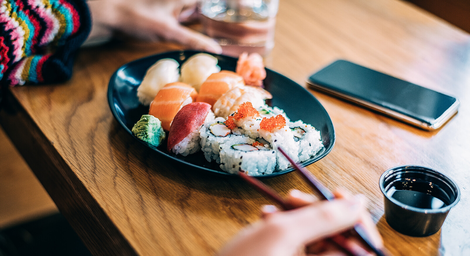 sushi bord met stokjes mobiel vrouw