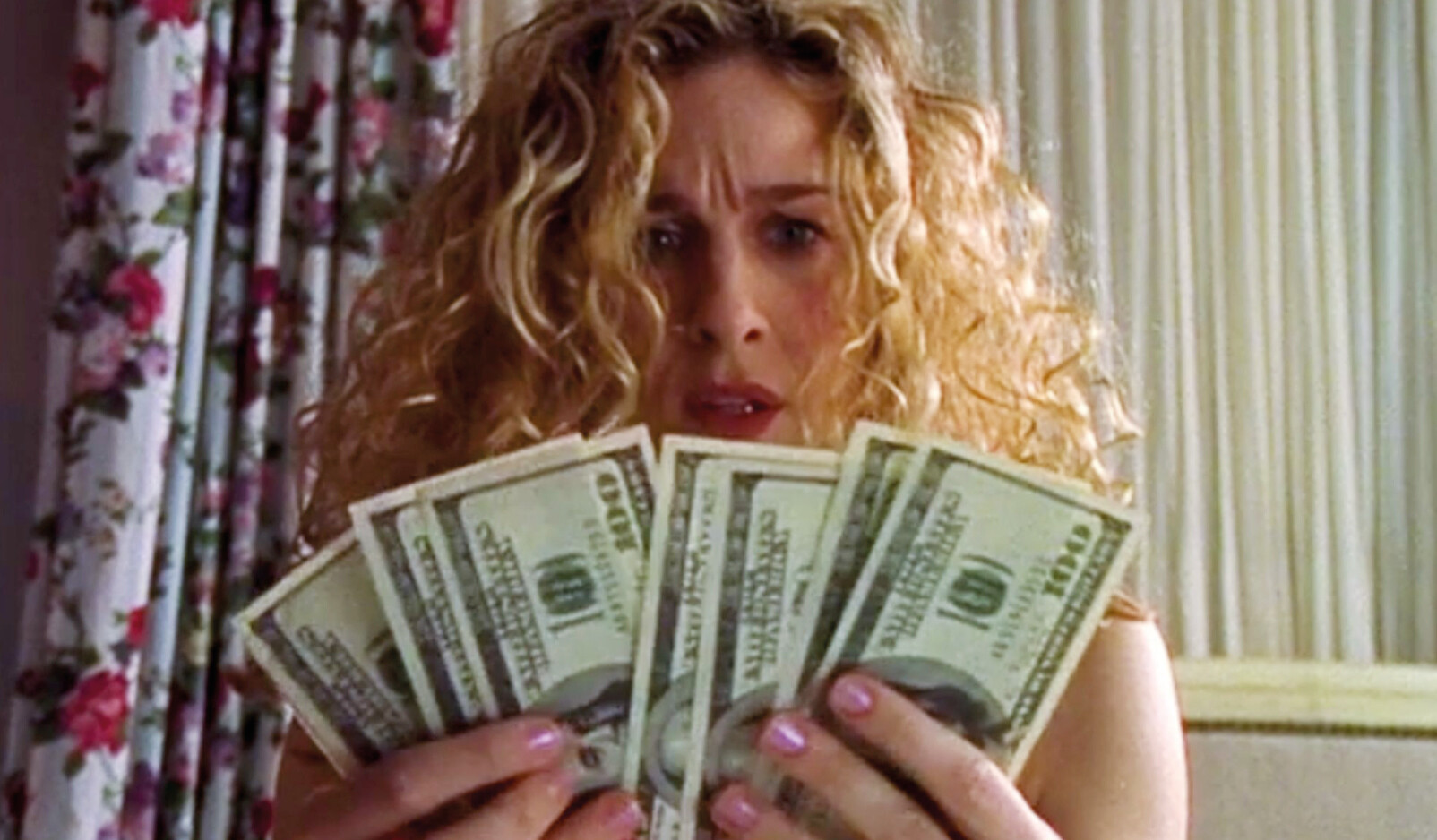 vrouw met heel veel dollars geld in haar handen blond krullend haar