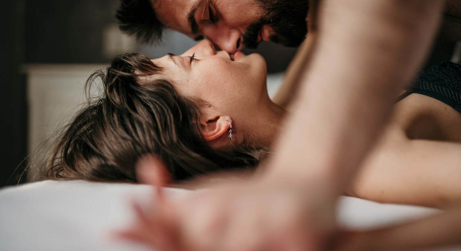 man en vrouw intiem in bed kussen