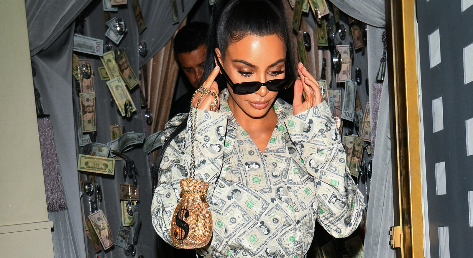 Kim kardashian loopt met dollar jas en tasje
