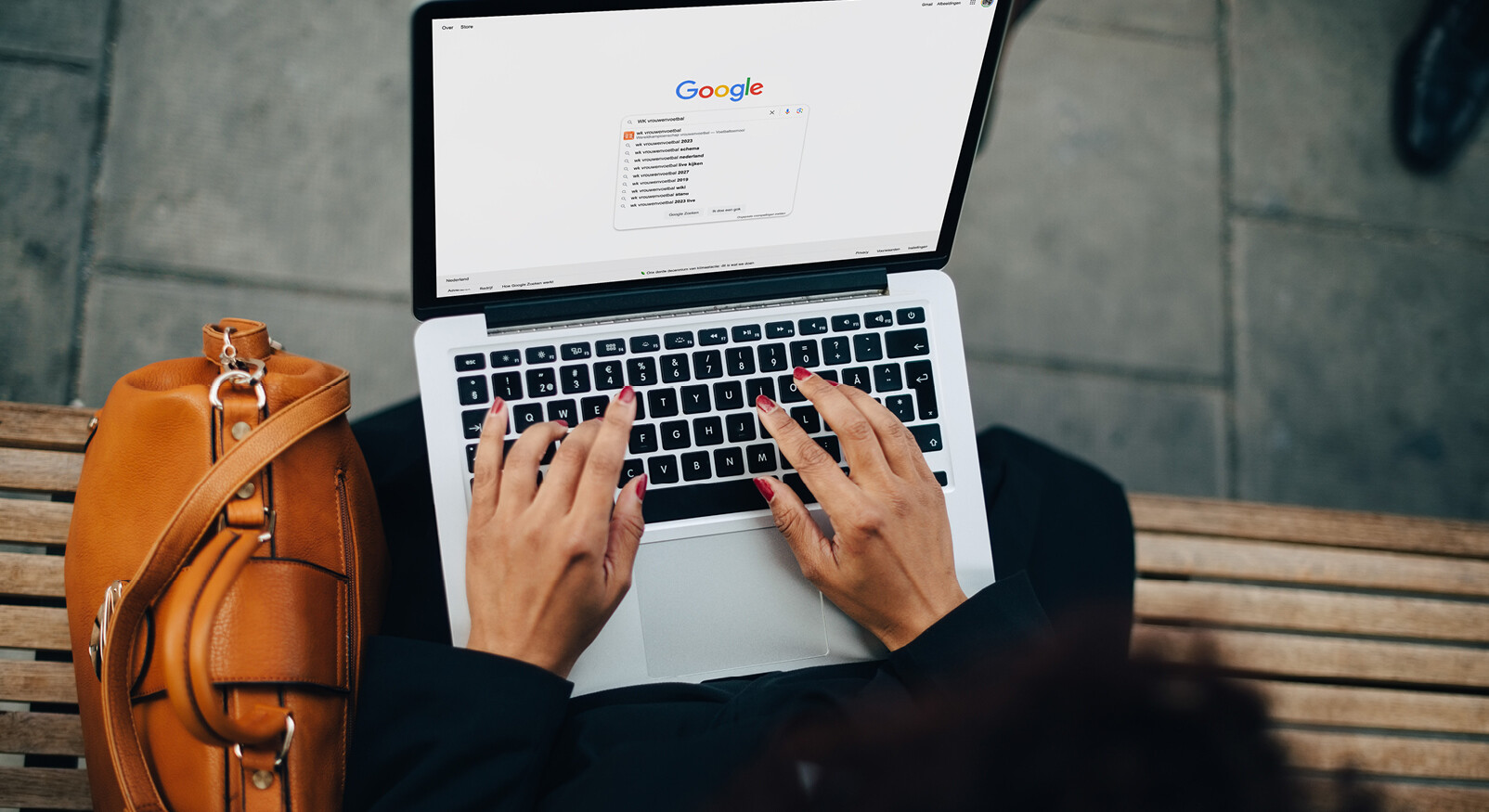 vrouw achter laptop google opdracht zoeken buiten bontjas