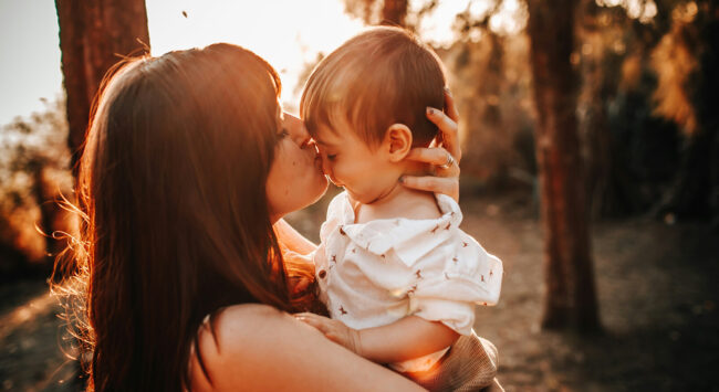 mother with baby sweet kiss outdoor photoshoot