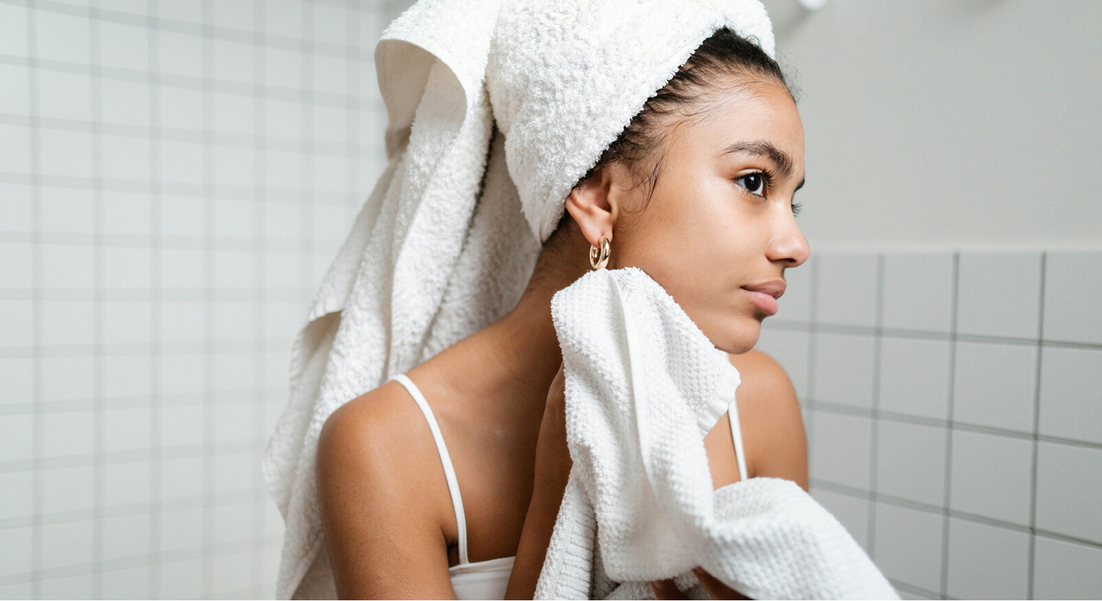 vrouw in badkamer make-up remover witte handdoek