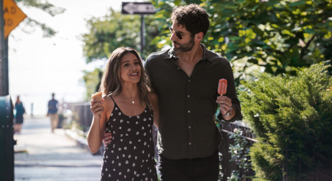 man and woman walking arm in arm with an ice cream
