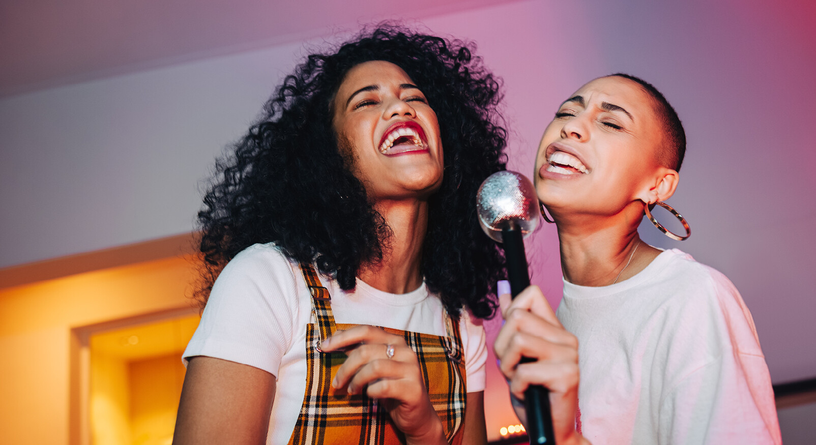 twee vrouwen lachen zingen karaoke