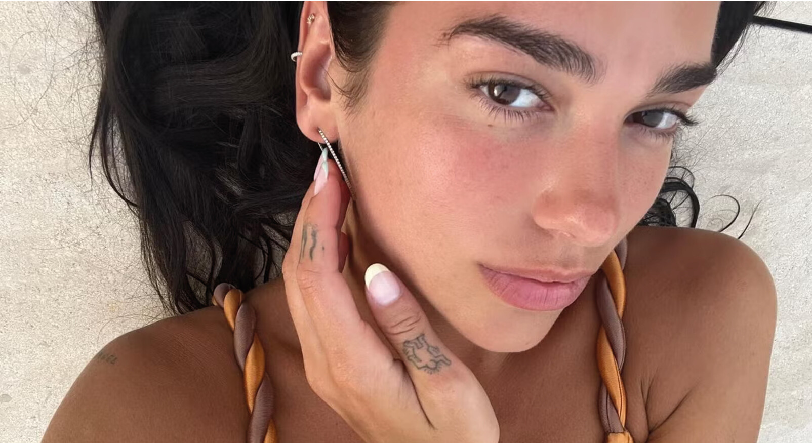 dua lipa kijkend naar camera in bikini zomerse kleur beauty