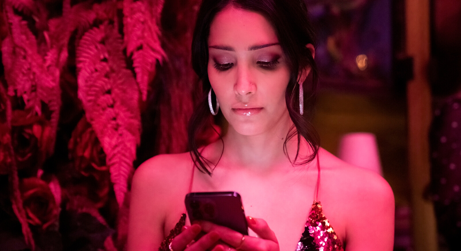 vrouw kijkt naar haar telefoon verbaasd vreemdgaan uitgaan relatie