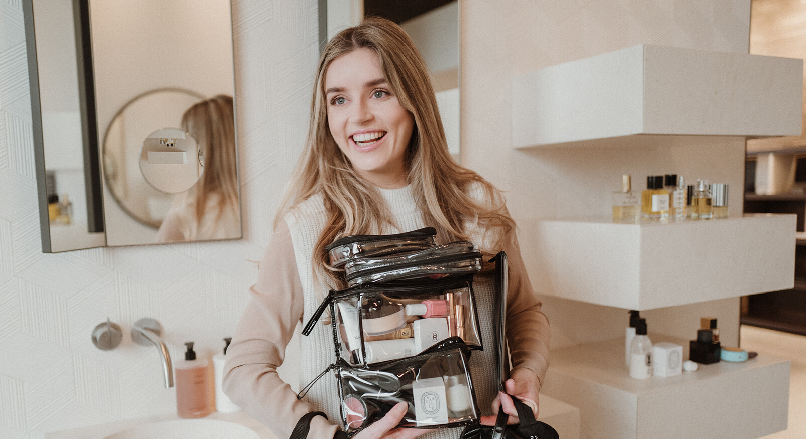 lotte van scherpenzeel lachend met beauty producten in haar handen toilettassen bij piet boon bathroom