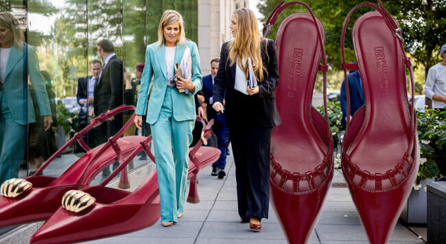 Maxima and Amalia walking in New York with two large red heels beside them