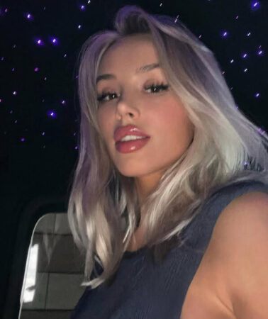 Model Violetta Bert met blond haar in een auto met paarse sterrenhemel, gelinkt aan Lewis Hamilton in 2025.
