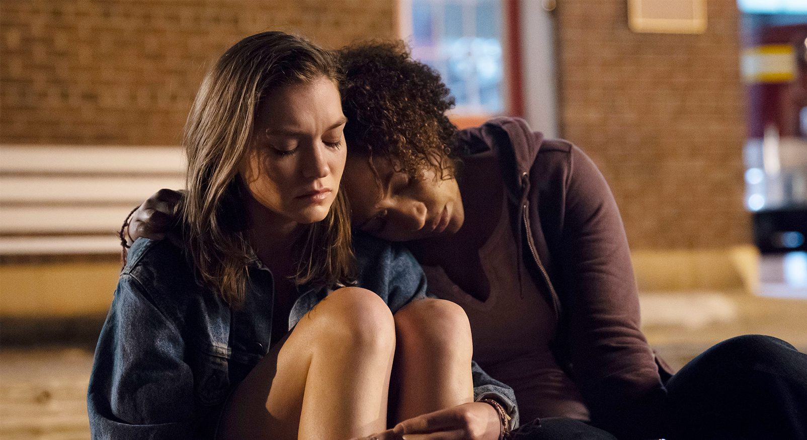 Scène uit de spannende serie The Sinner, met twee jonge vrouwen in het donker, de een troost de ander.