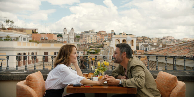 man and woman drink coffee together on a terrace