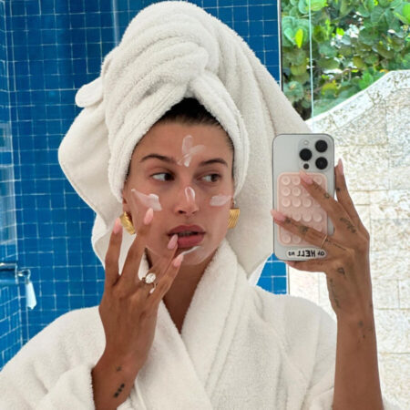 Hailey Bieber kijkt in spiegel en smeert creme