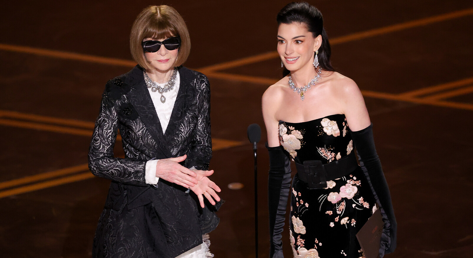 anna Wintour en anne Hathaway op podium