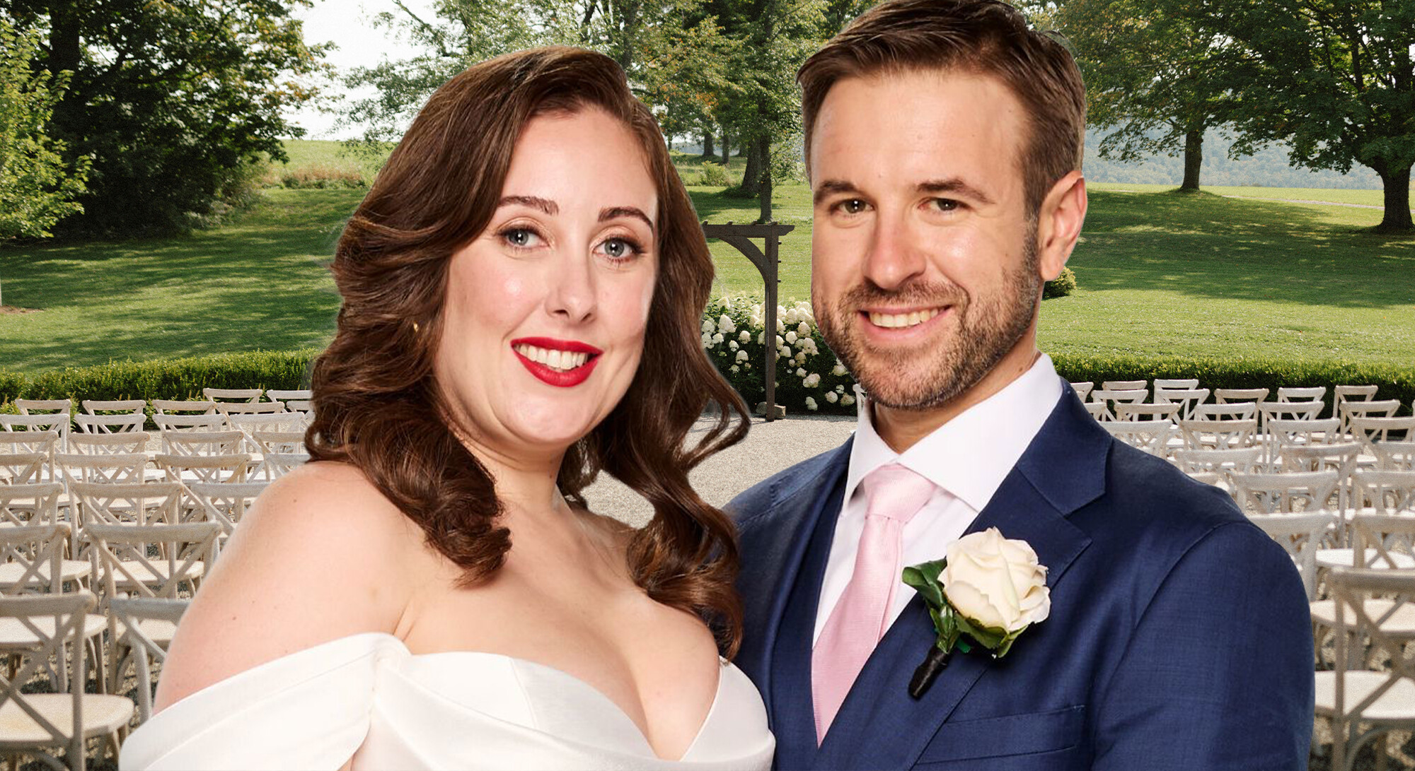 Een bruidspaar poseert glimlachend in een tuin. De vrouw draagt een kanten jurk met dunne bandjes en een sluier; de man draagt een donkergroen pak met een zwarte vlinderdas en een dieprode bloemencorsage. De omgeving is groen met veel bomen.