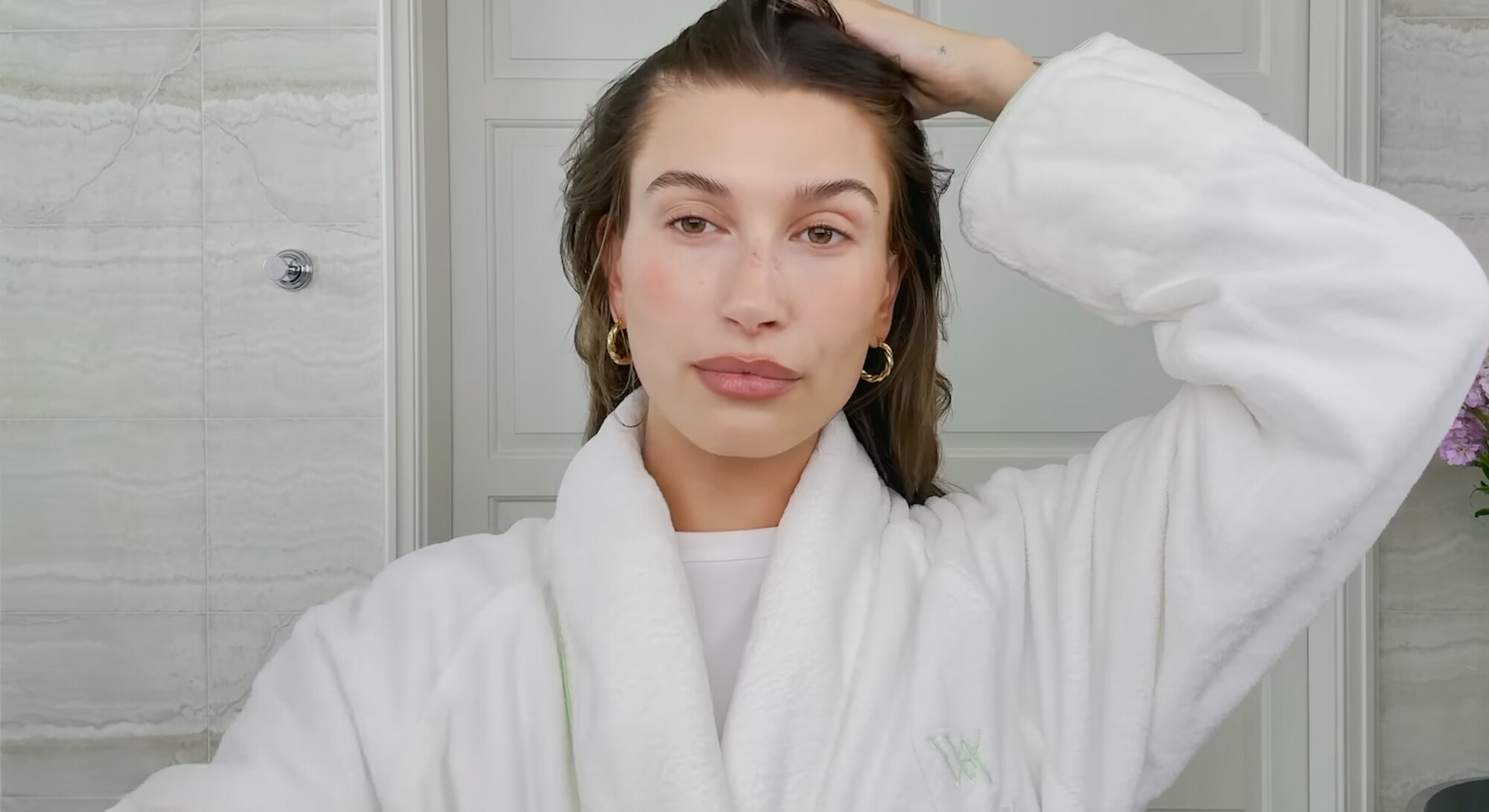 Hailey Bieber in badjas tijdens haar ochtendroutine in de badkamer