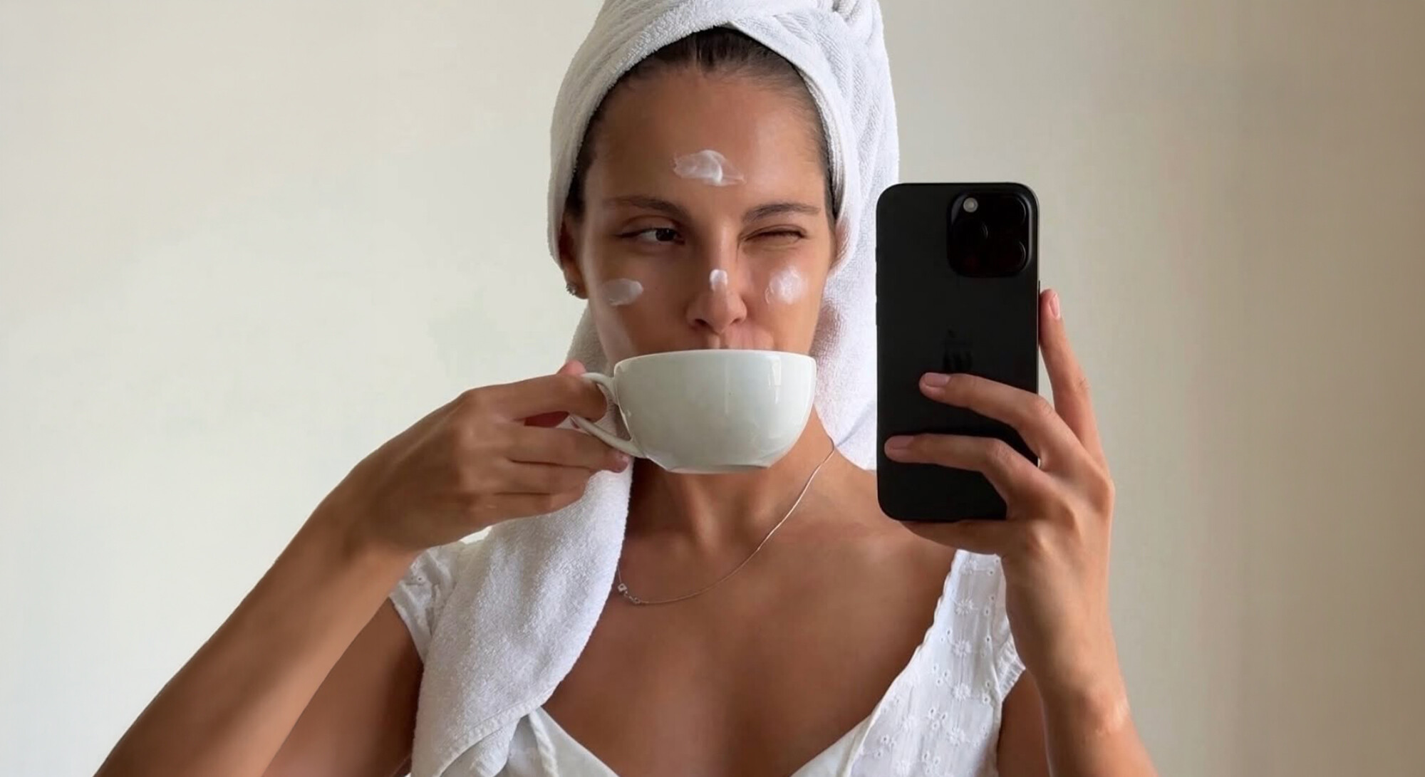 vrouw met creme op haar gezicht, en crème potten
