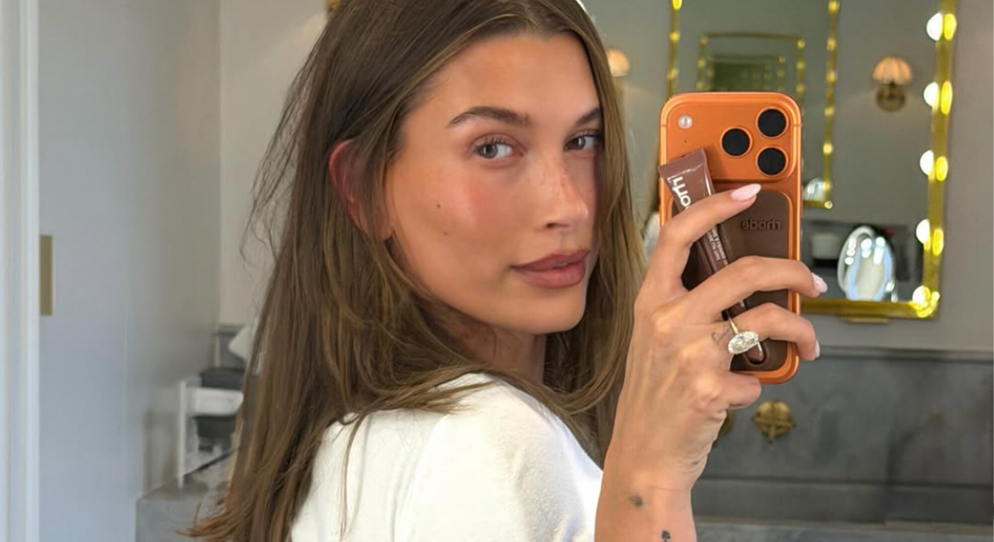 Hailey Bieber maakt een spiegelselfie in de badkamer
