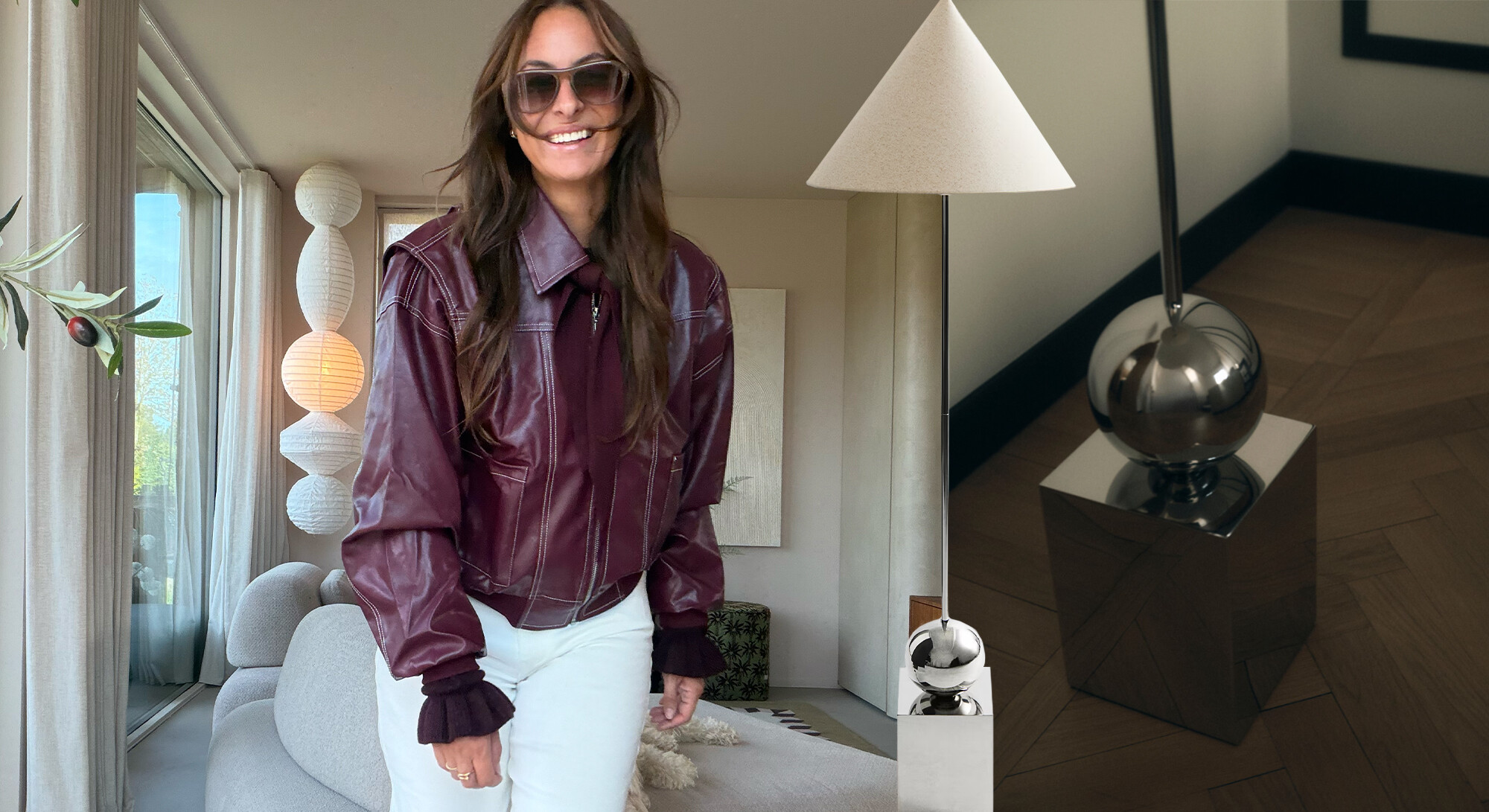 Vrouw in bordeauxrode leren jas en witte broek naast moderne zilverkleurige H&M Home-lamp in stijlvol interieur.