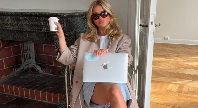 Vrouw met laptop en koffie die haar dagelijkse routine na de zomer weer oppakt.