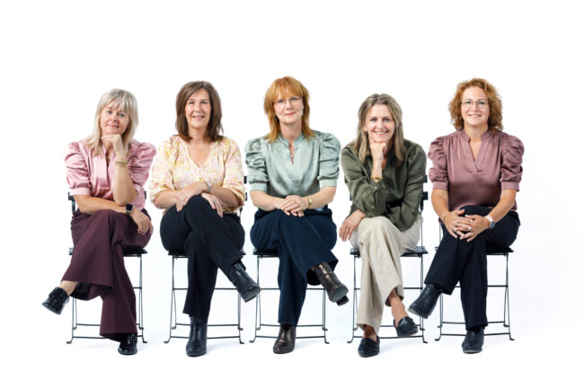 vrouwen op een rij op een krukje