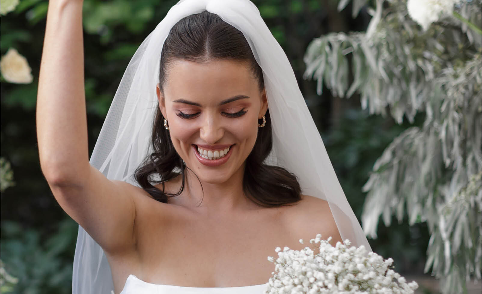 bruid lachend bruiloft bloemen sluier