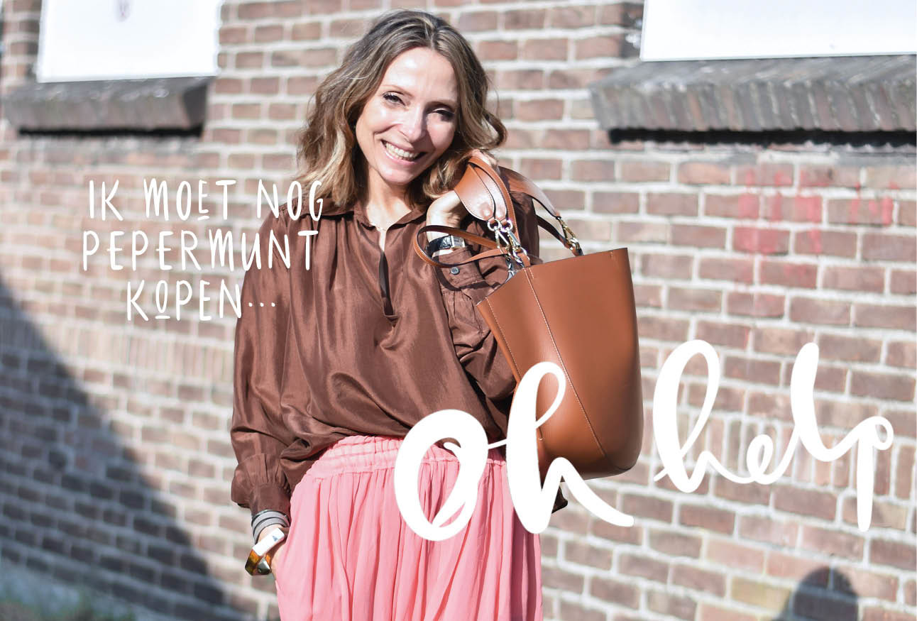 May-britt lachend buiten op straat met Wandler tas en roze rok