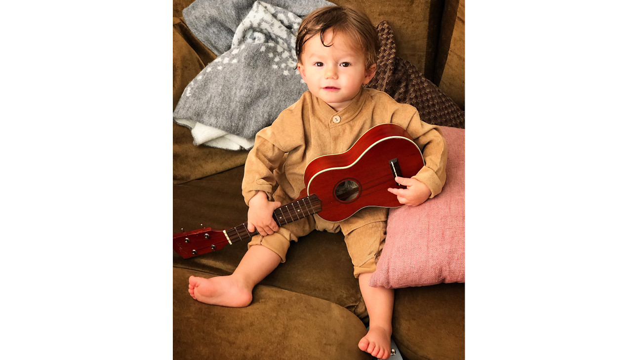 baby otis met een gitaar in zijn hand op de bank