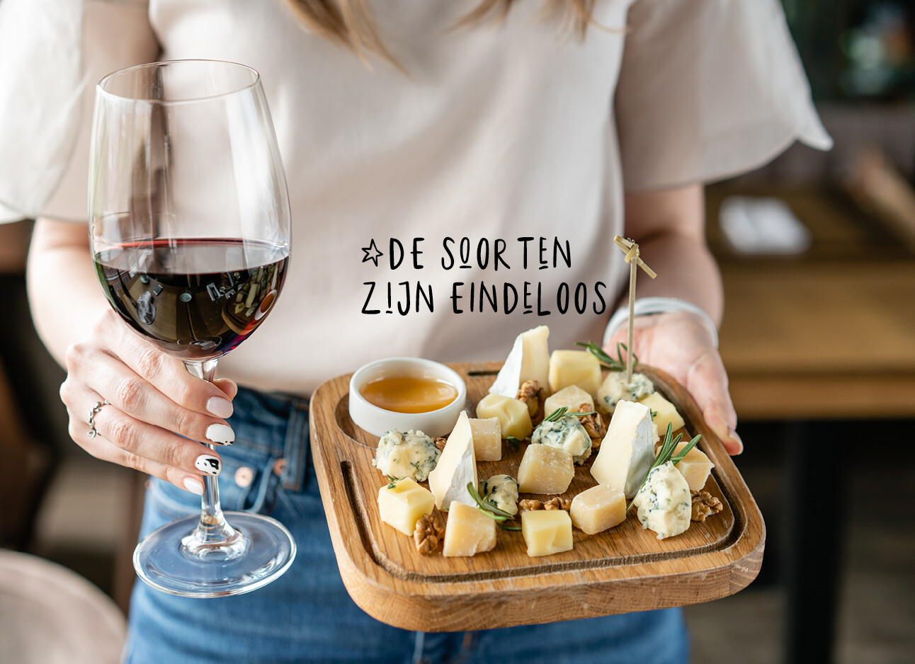 Vrouw met een glas rode wijn en een kaasplankje