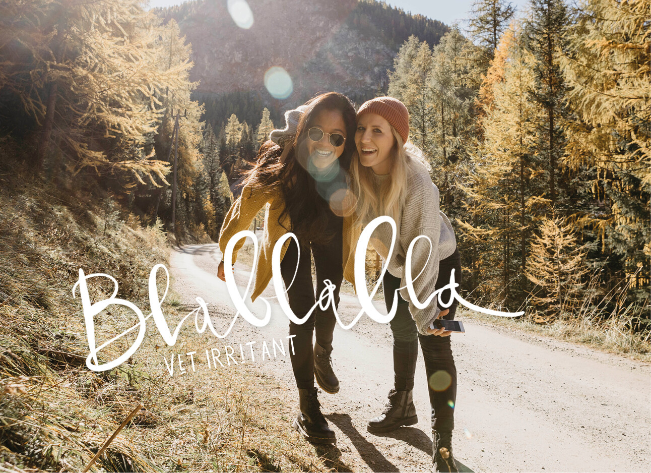 2 vrouwen backpacken door de bergen en lachen met elkaar