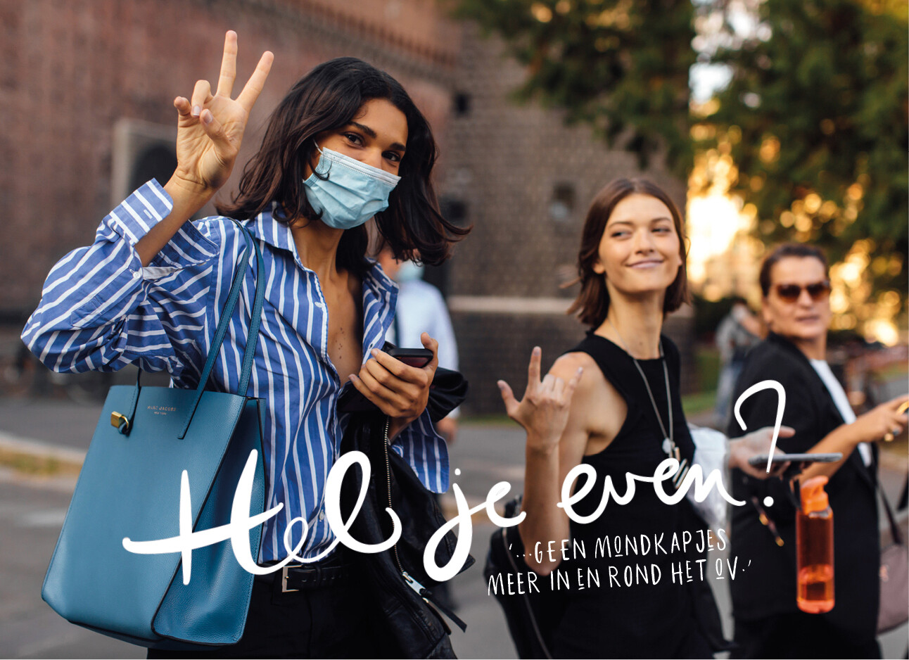 3 vrouwen vrolijk lopend op straat met mondkapje