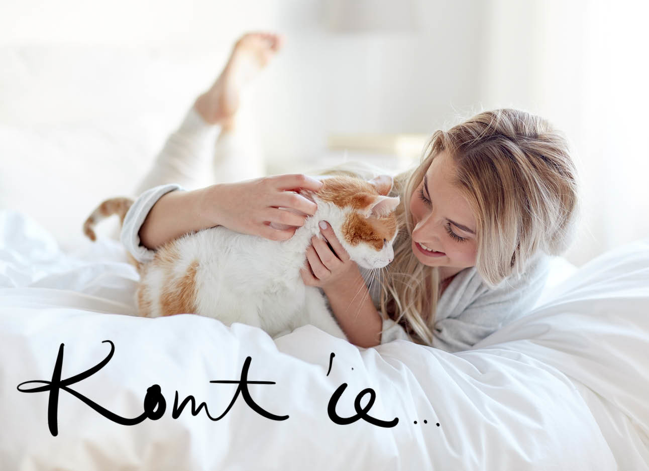 Vrouw en kat knuffelen op bed