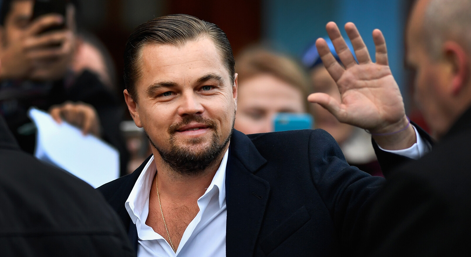 Leonardo Di Caprio lachend zwaaien naar fans op straat