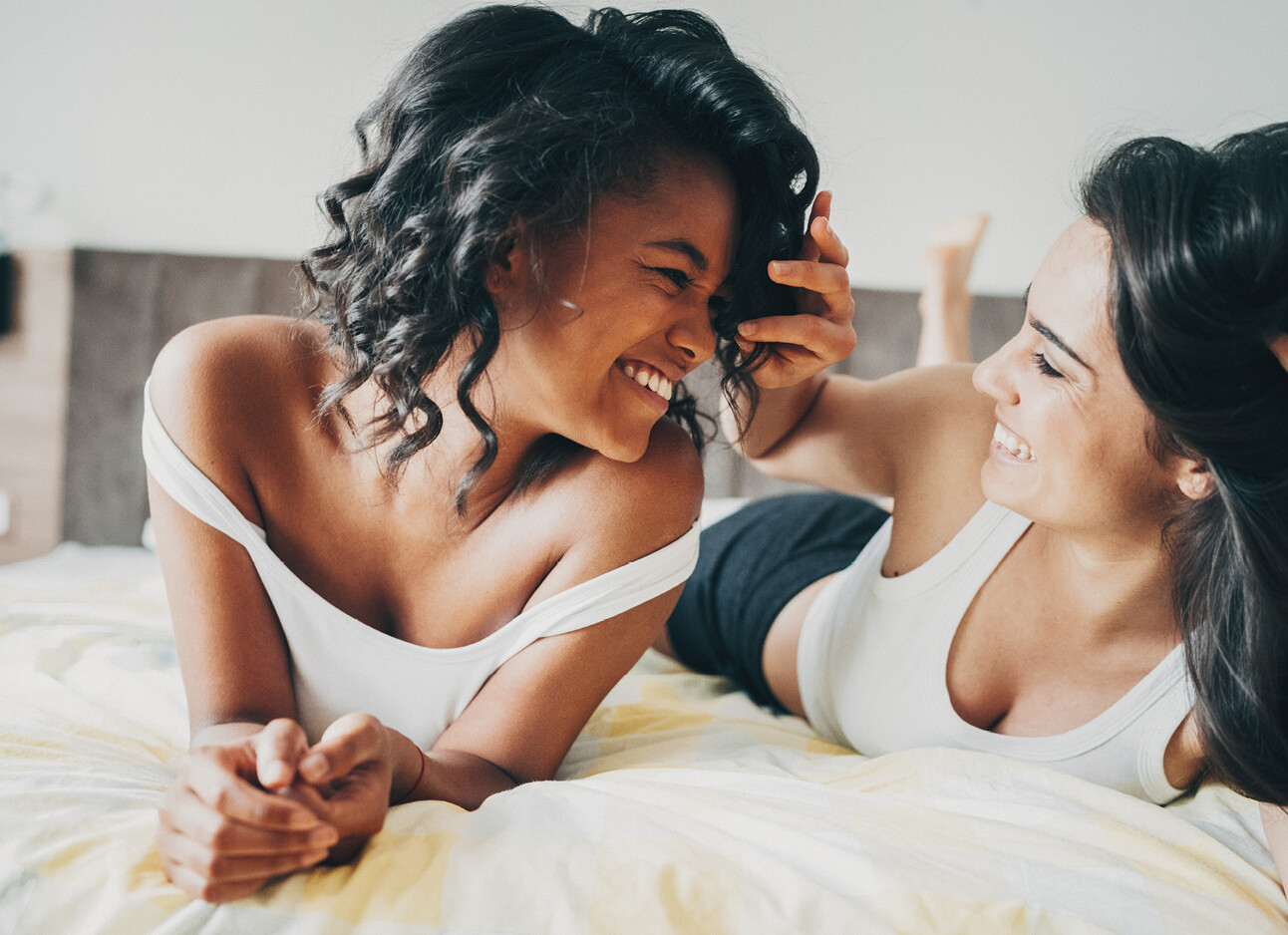 twee vrouwen intiem in bed lachend