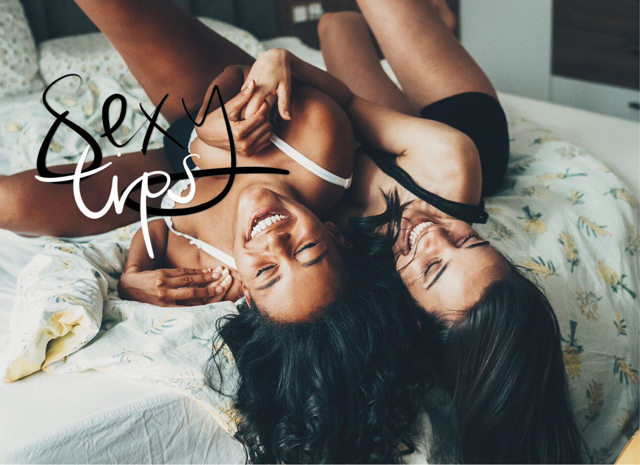 twee vrouwen in bed in lingerie lachen met elkaar