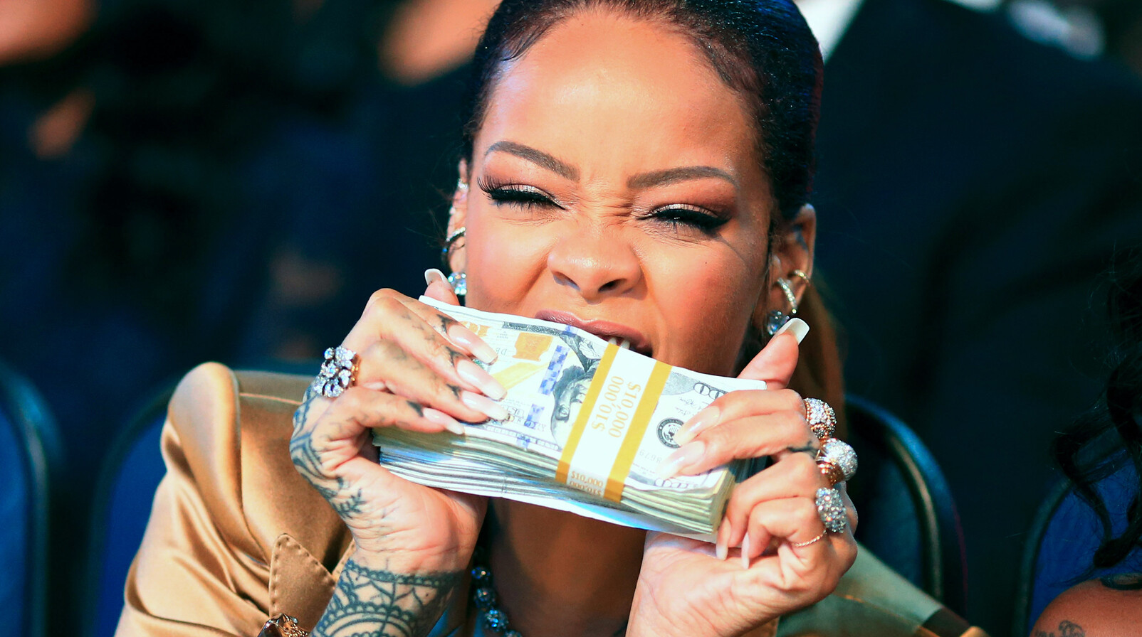 Rihanna met geld in haar mond dollars lachend sieraden