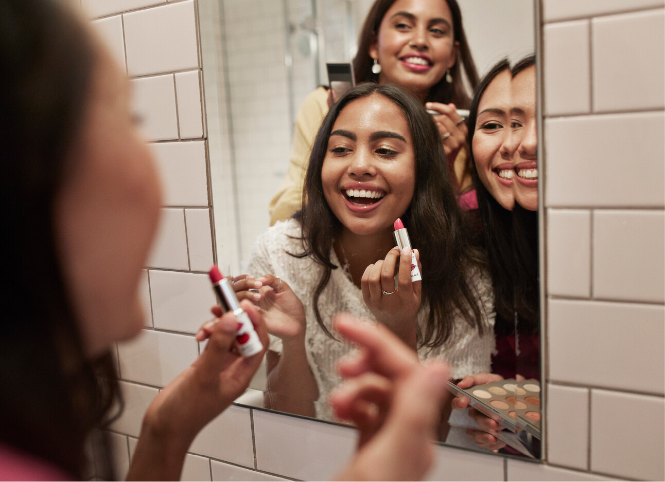 vriendinnen feestje in de spiegel lipstick dragen make-up lachen