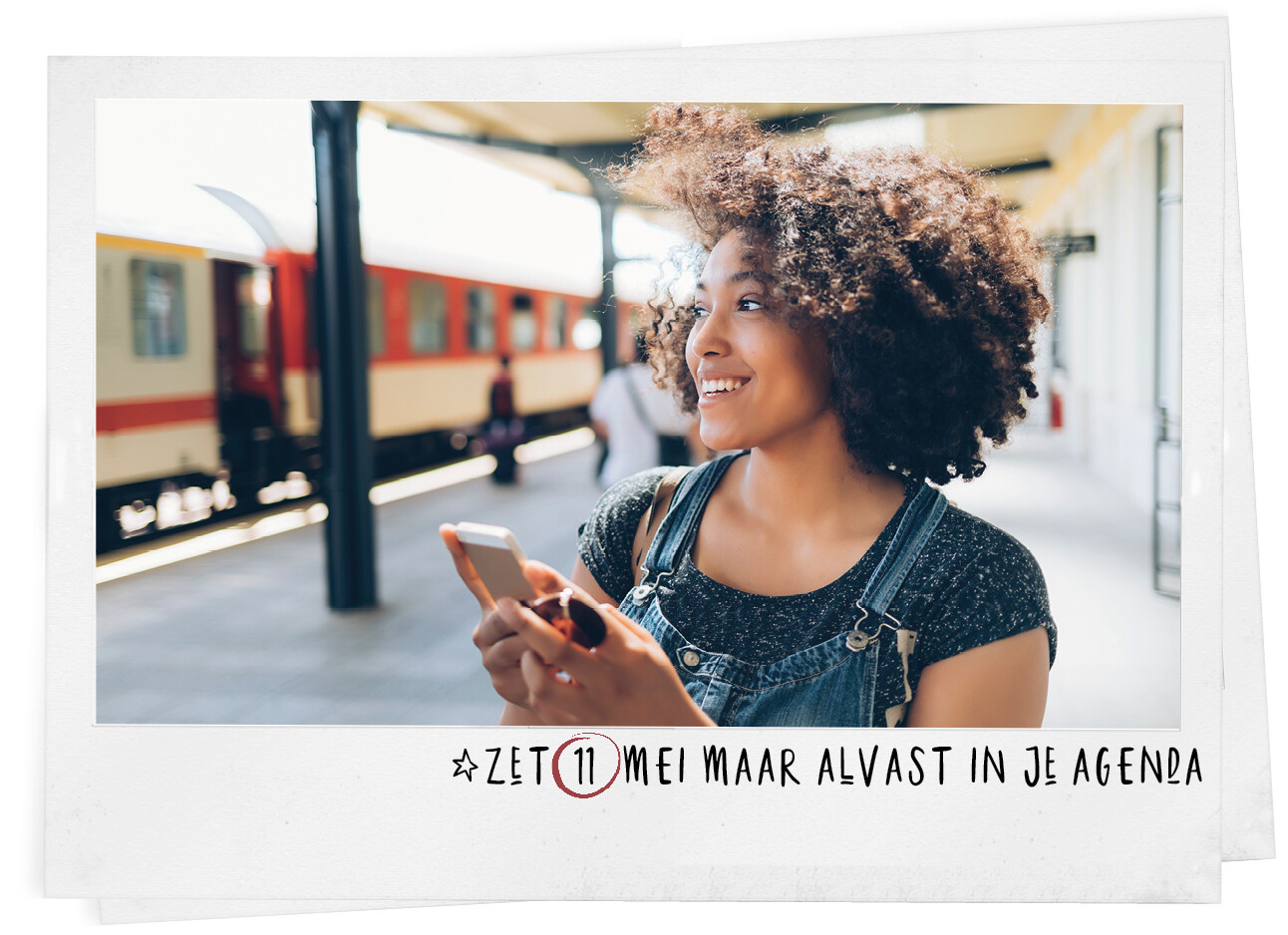 Vrouw lachend met haar telefoon op het trein station