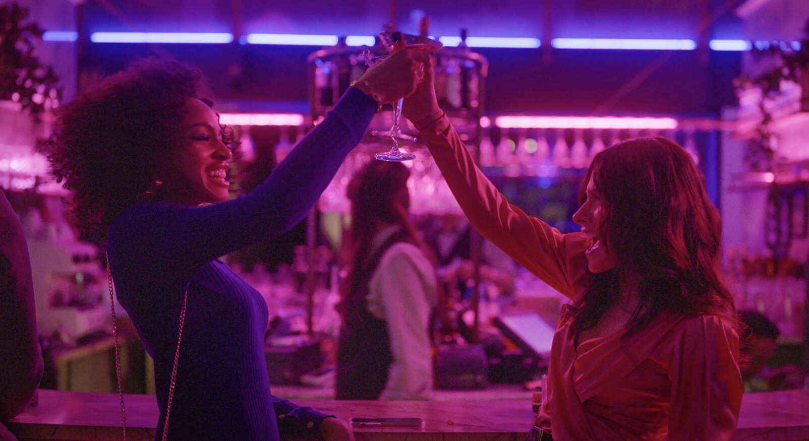 Twee vrouwen lachen in de club proosten cocktail